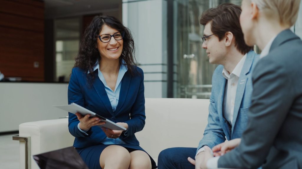 Professionals discussing business strategy in a corporate office setting.